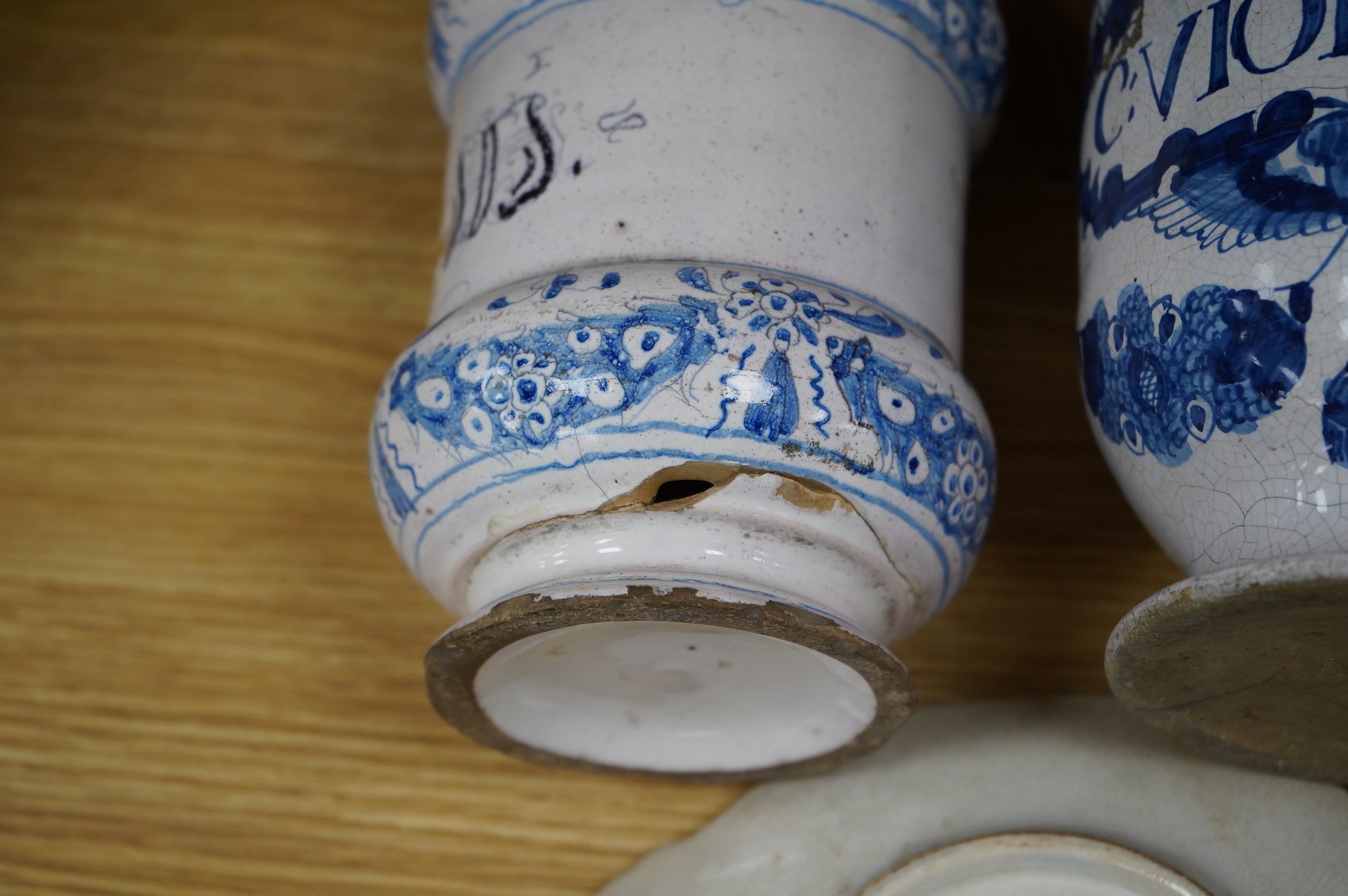 A 17th /18th century blue and white Delft apothecary jar, together with an Italian blue and white pottery drug jar and a blue and white ‘Saxon Star’ two handled dish, tallest 19cm. Condition - poor